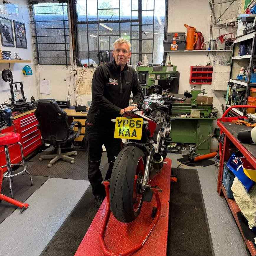 Scott of SNS Motorcycles with a bike on the stand in the workshop