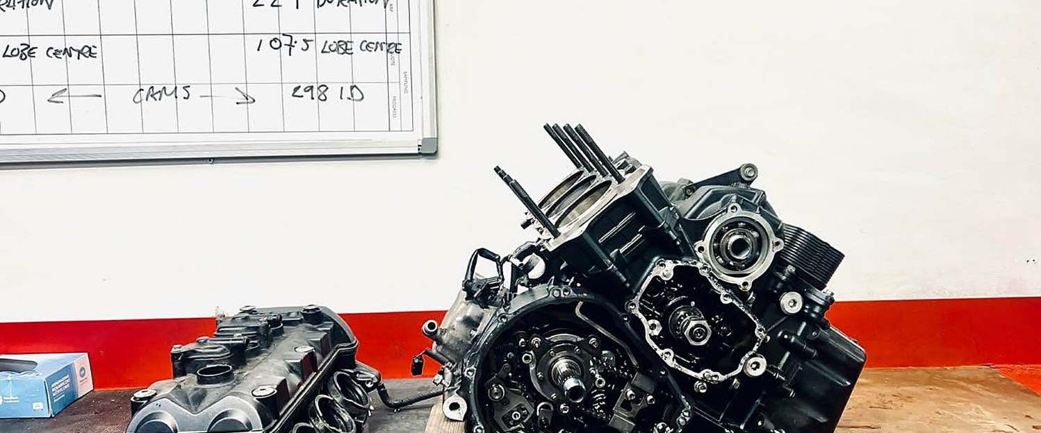 Engine components laid out on the workshop bench during a strip-down