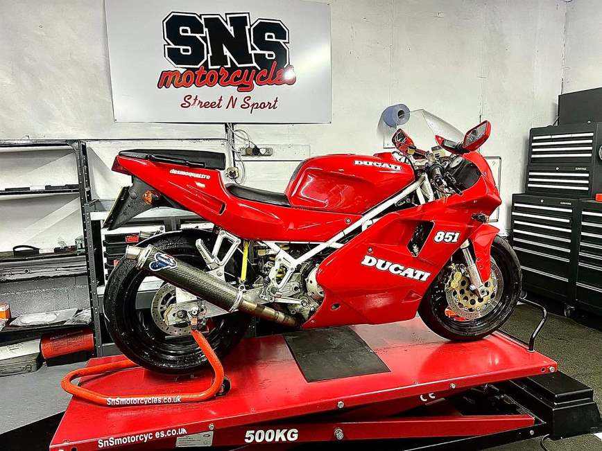 Ducati on the red lift beneath the SNS Motorcycles banner
