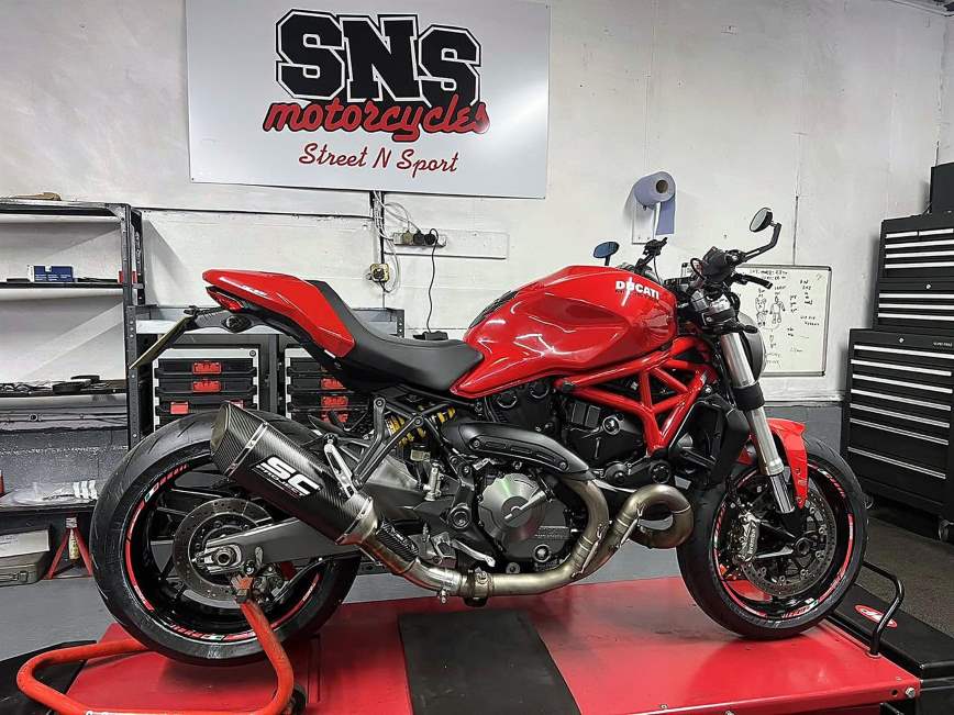 Ducati Monster with aftermarket exhaust on the SNS workshop lift